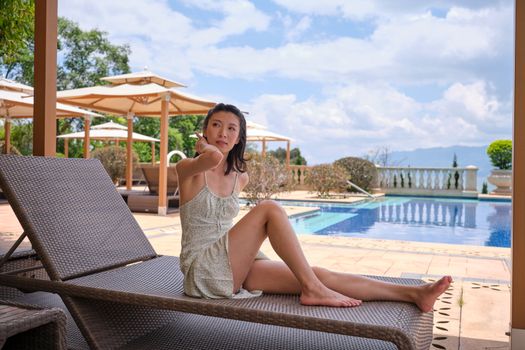 A Woman Sitting on an Outdoor Chaise Lounge Chair