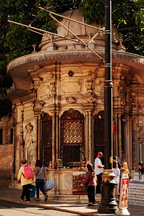 Free A lively street by a historical kiosk with ornate architecture and people shopping. Stock Photo