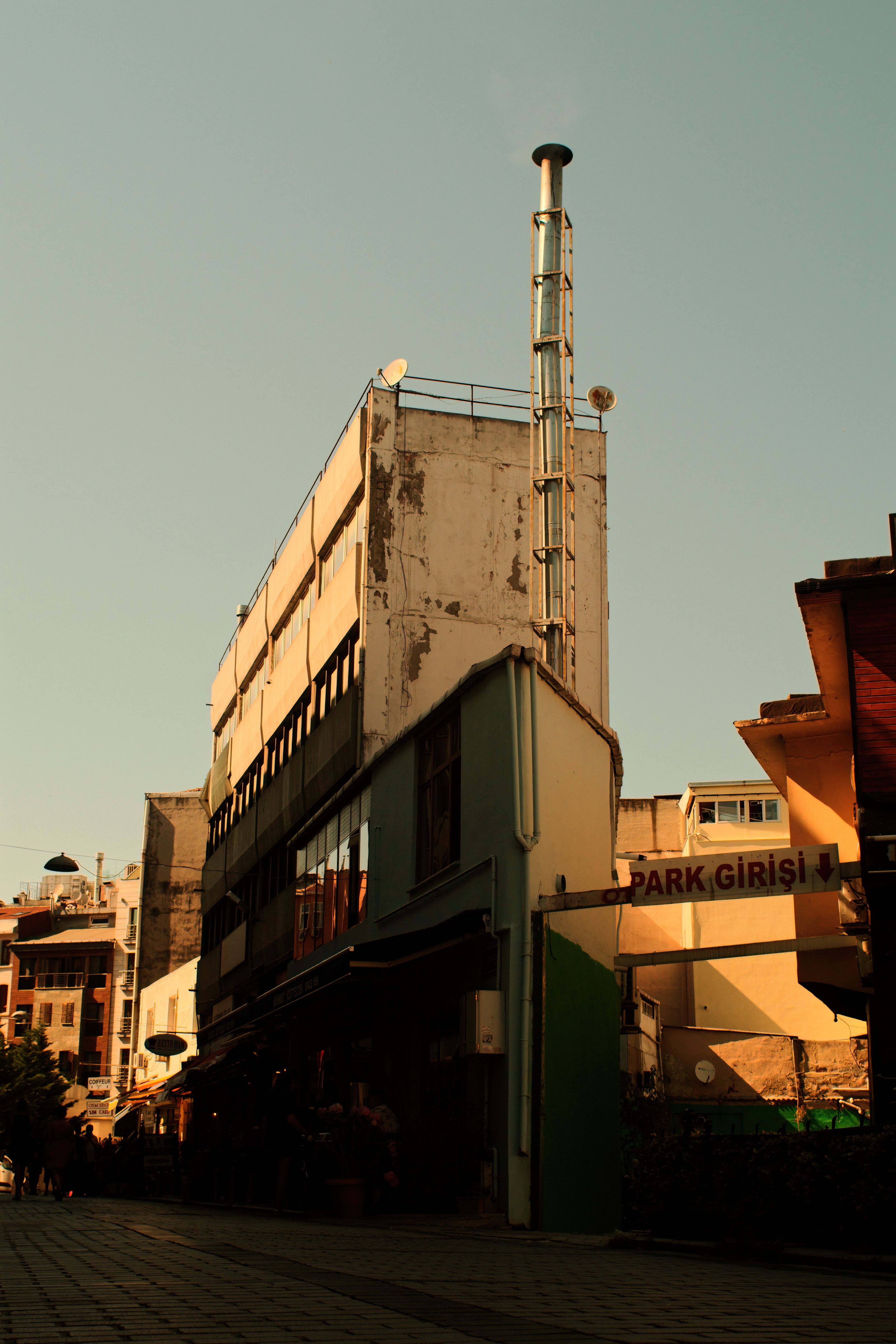 Urban cityscape featuring a rustic industrial building under a clear blue sky.