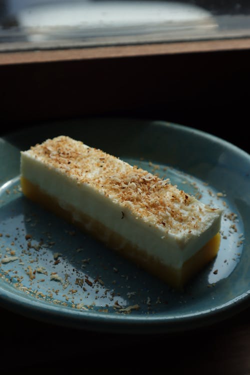 Slice of Dessert with Toasted Coconut on Blue Ceramic Plate