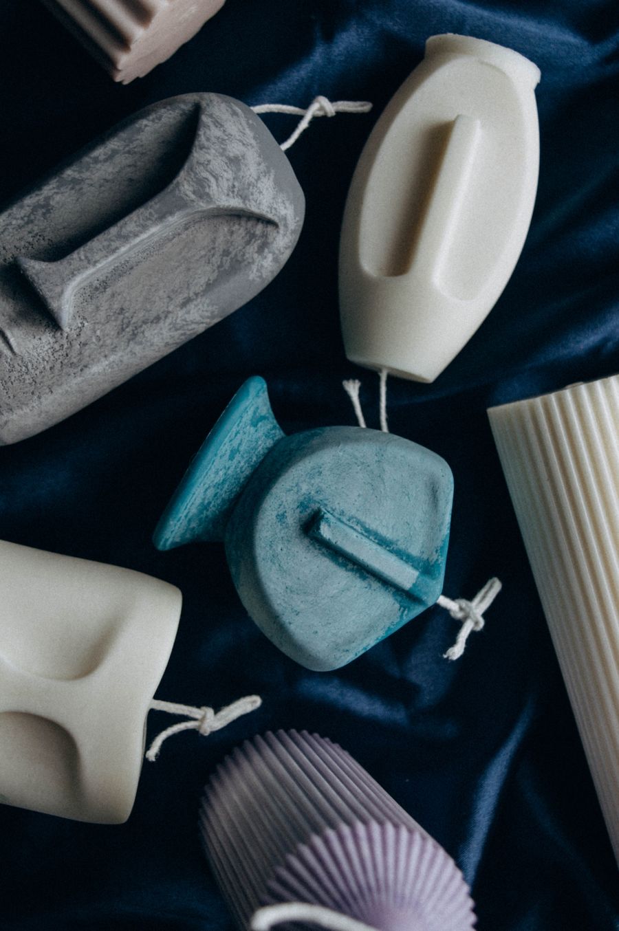 Hand-poured sculptural candles on dark textured cloth — photo by Liudmyla Shalimova on Pexels