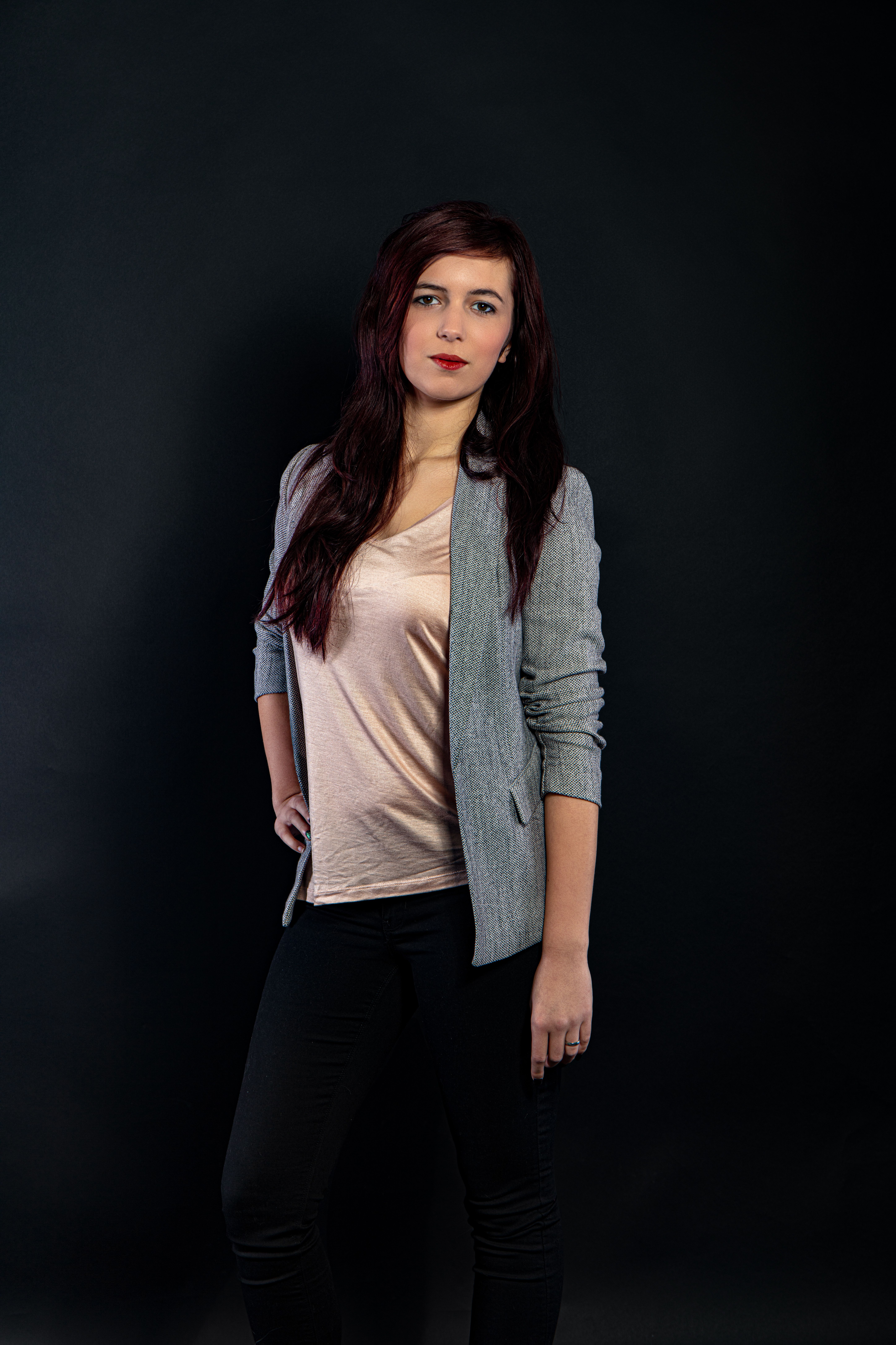 Elegant woman posing in a studio with black background.
