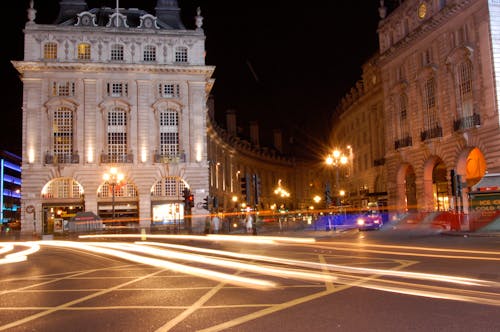 Piccadilly circus, famous road junction and public space of London's West End in the City of Westminster. Night shoot. Traditional victorian buildings from 1819 with car light trails.