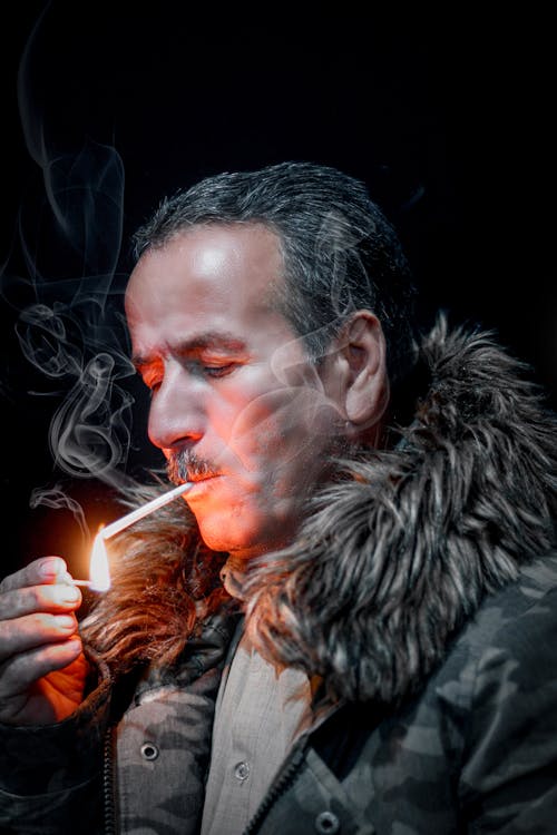 Free Man Lighting a Cigarette with a Matchstick Stock Photo