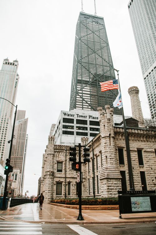 Free A rainy day view of Chicago's iconic Water Tower with skyscrapers in the background. Stock Photo