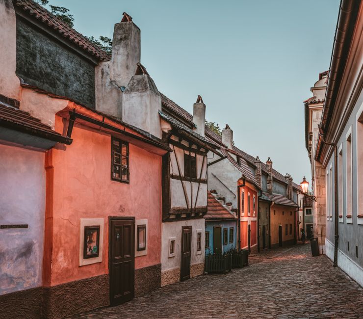 Capture of a quaint alleyway lined with colorful historic buildings reflecting warm evening light.