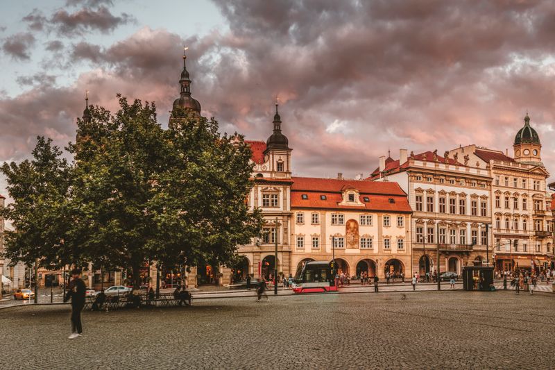 Capture of a European city square at sunset with historical architecture and vibrant sky.
