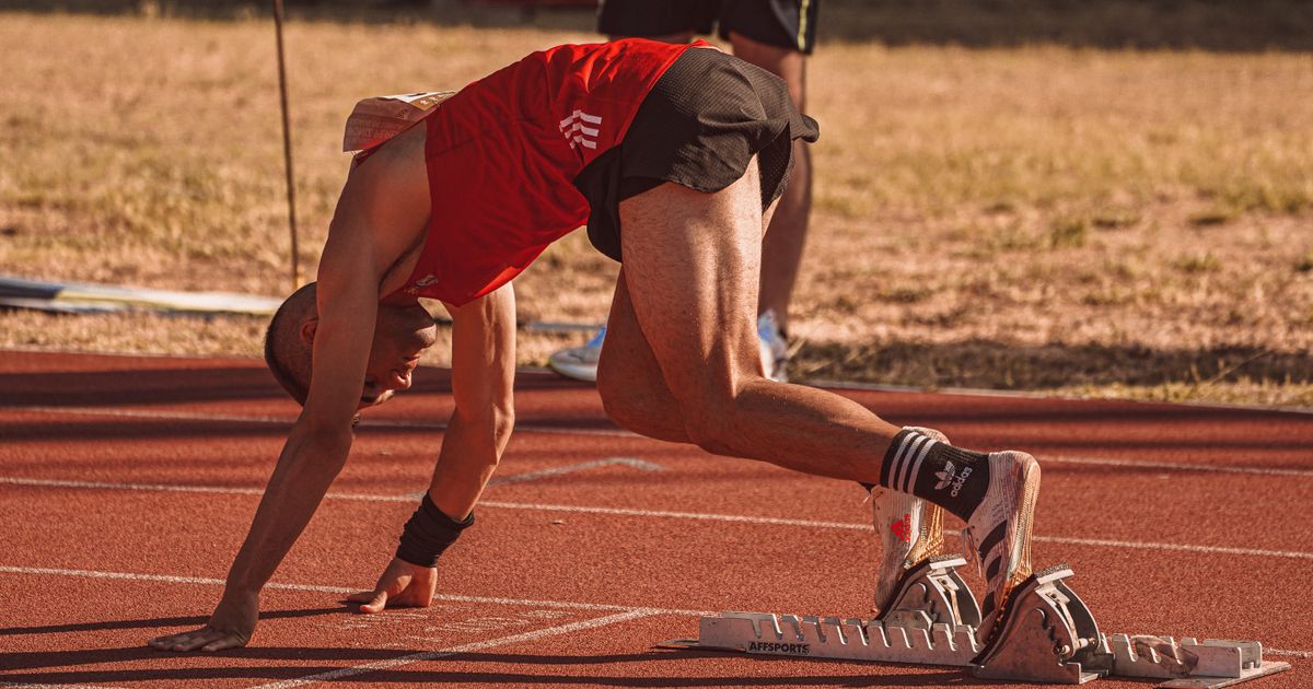 A sprinter training on a track, showcasing their unique starting technique.