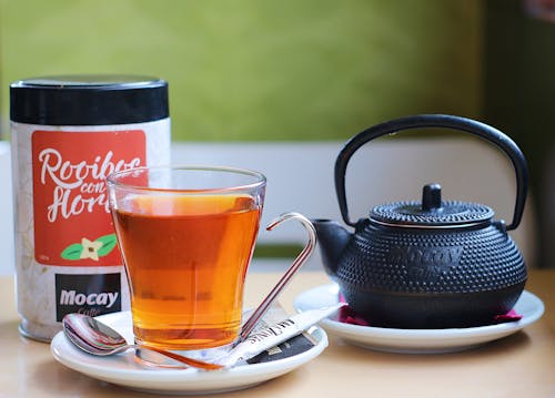 Free Black Teapot Beside Clear Glass Mug on White Ceramic Plate Stock Photo