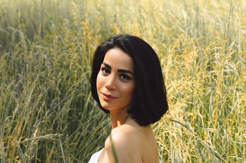 Woman in White Off Shoulder Top Standing on Yellow Grass Field