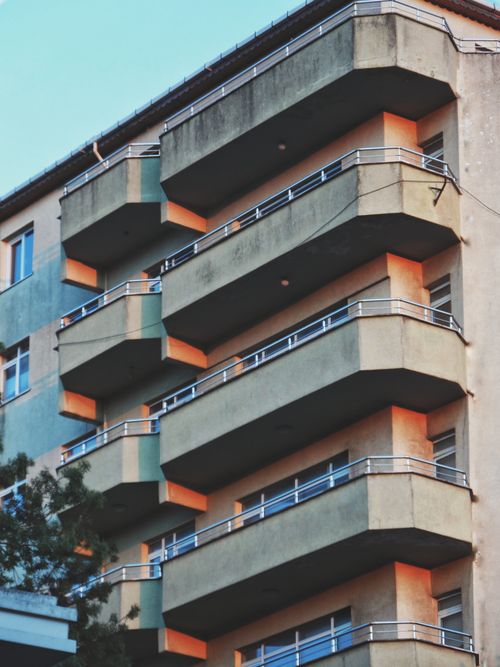 Free Close-up of an urban residential building with multiple balconies in a city setting. Stock Photo