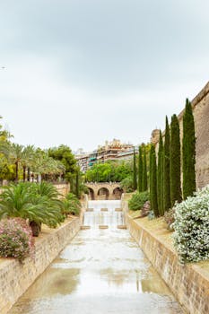 Beautiful garden with fountain and stone pathways in Mallorca, Spain, featuring lush plants and architecture.