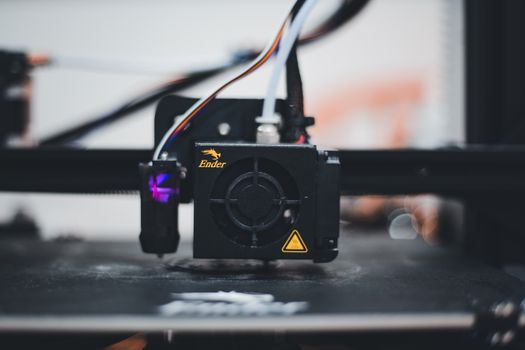 Detailed view of a 3D printer nozzle during the printing process, showcasing advanced technology.