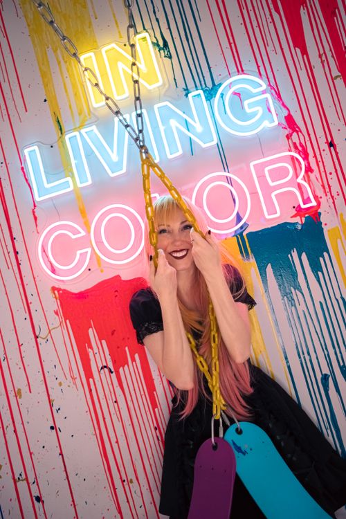 Free Colorful portrait of a woman posing with neon lights and splattered paint background. Stock Photo