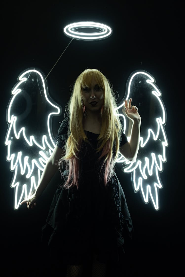 Woman In Black Dress With Illuminated Wings And Halo