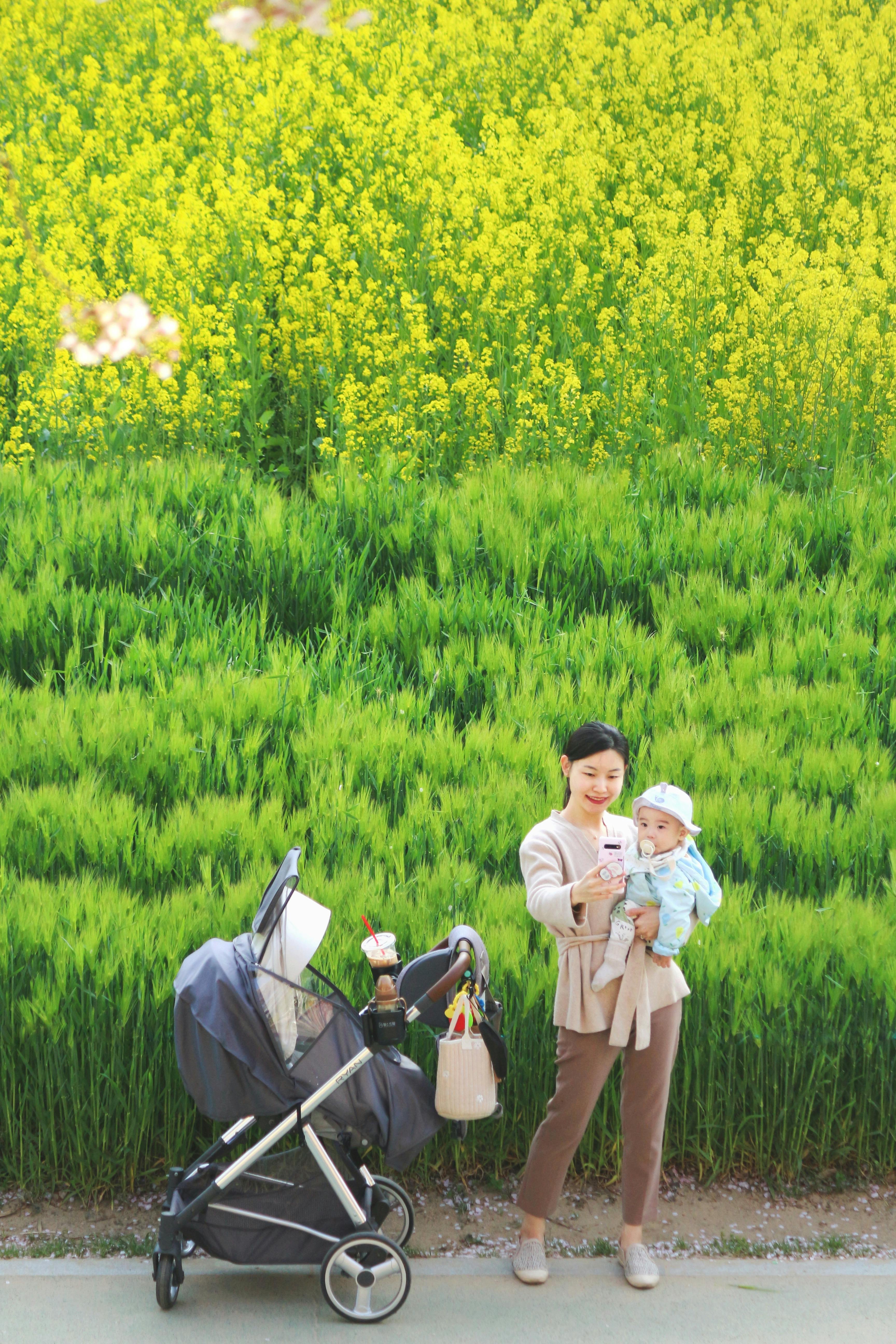Asian mother with baby in nature, South Korea, vibrant spring scene