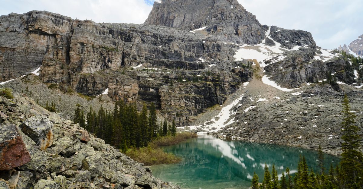 Stunning view of a turquoise lake surrounded by rocky mountains in Field, BC, Canada.
