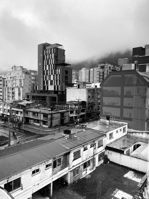 Stunning black and white view of a foggy urban landscape in Colombia showing diverse architecture.