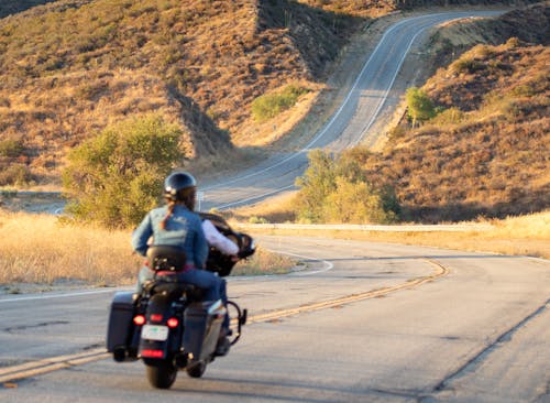 People riding a Motorbike in a Country Road 