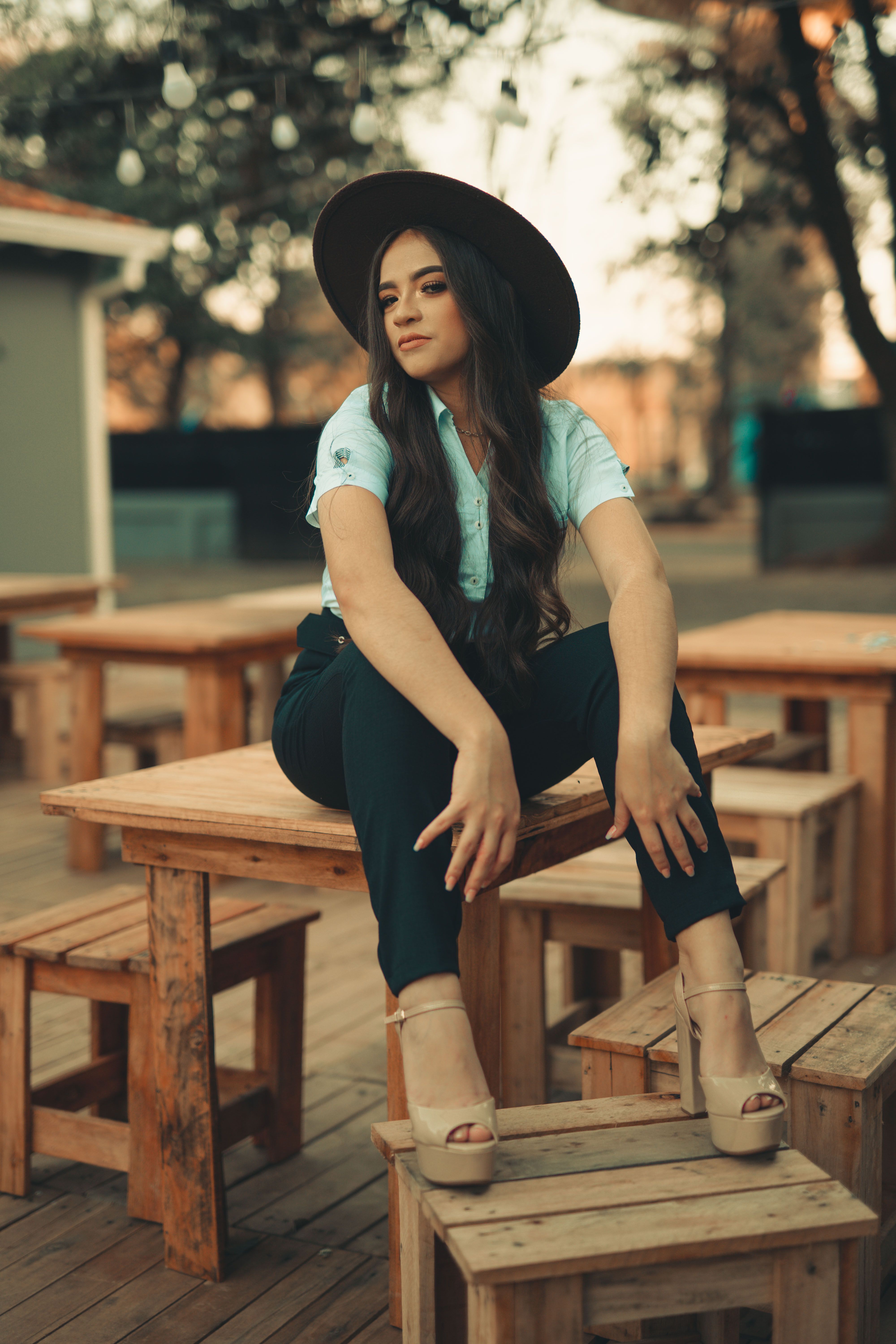 Woman in a Hat Sitting on a Table · Free Stock Photo