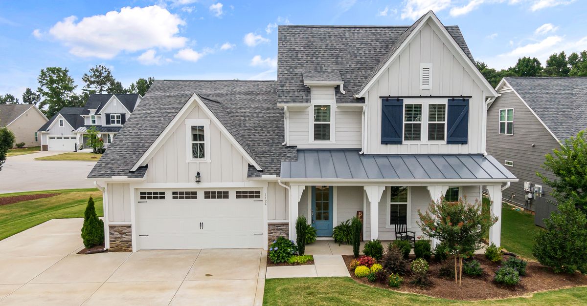 Elegant suburban home with a modern facade and lush yard in Fuquay-Varina, NC. Perfect for real estate listings.