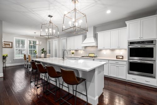 Free Sleek modern kitchen featuring white cabinetry, spacious island, and stylish lighting for a contemporary home design. Stock Photo
