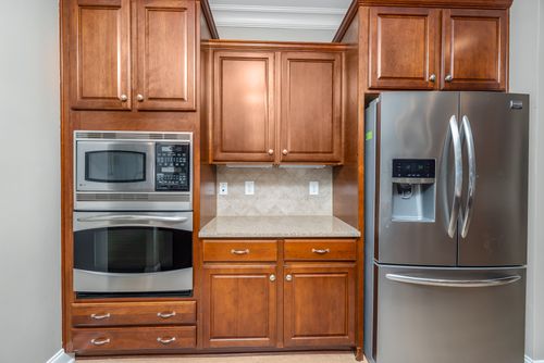 Free Elegant kitchen featuring stainless steel appliances and wooden cabinets. Stock Photo