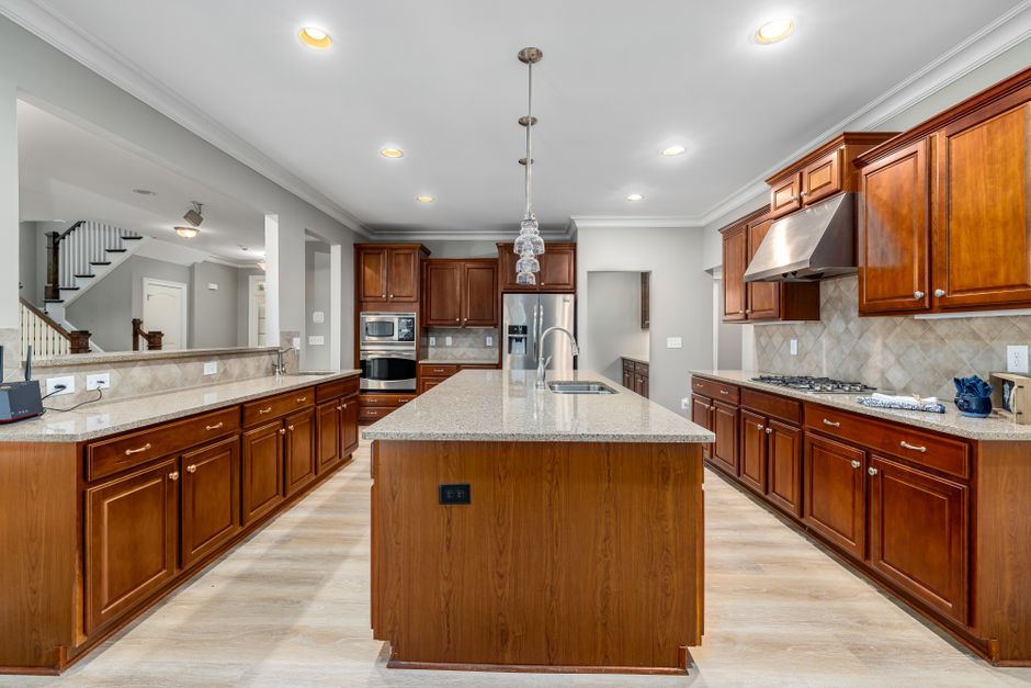 Discover a modern kitchen with sleek wooden cabinets and a central island.