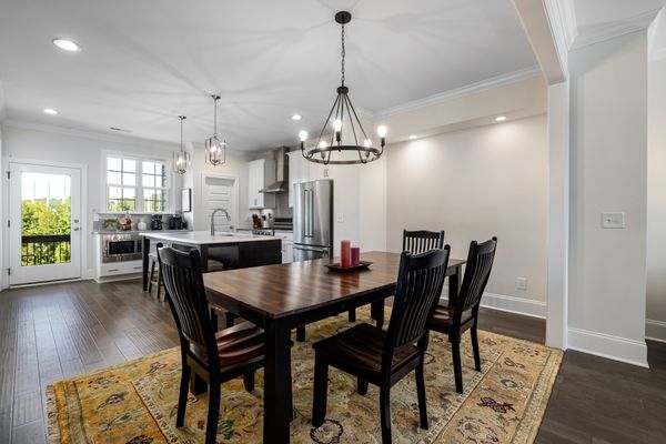 A ring chandelier hung over a walnut dining table. Photo by Curtis Adams on Pexels