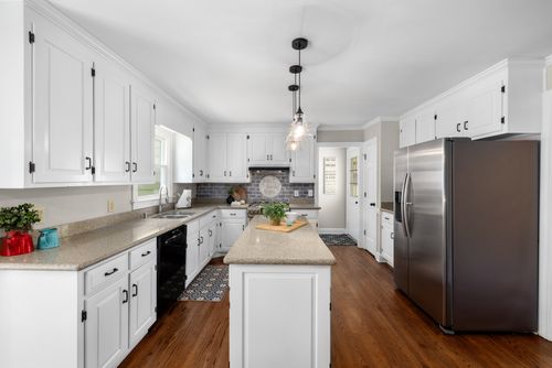 Free Bright and spacious kitchen with modern white cabinetry and a central island. Stock Photo