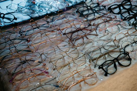 A variety of eyeglasses with metal and plastic frames neatly arranged on a table.