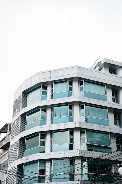 White Concrete Building with Glass Windows Under White Sky