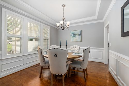 Free Elegant dining room featuring classic furniture, soft lighting, and modern interior design elements. Stock Photo