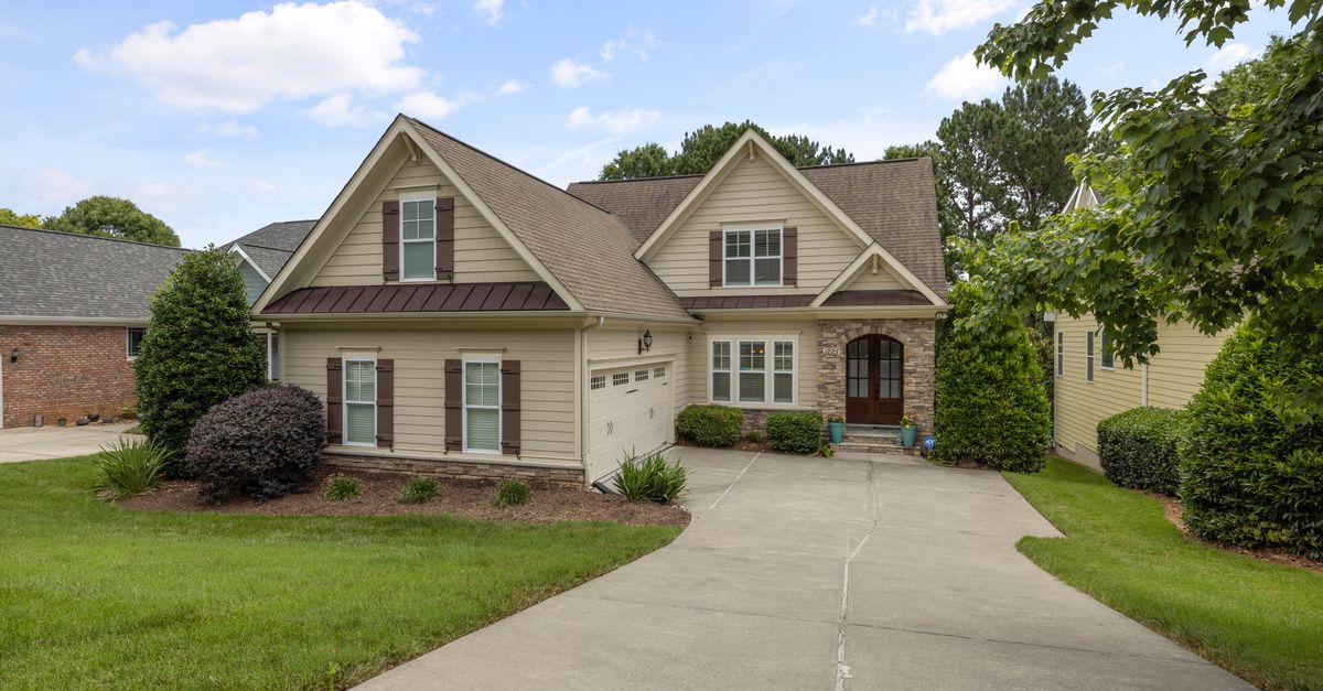 A beautiful suburban family house with a well-maintained lawn and driveway.