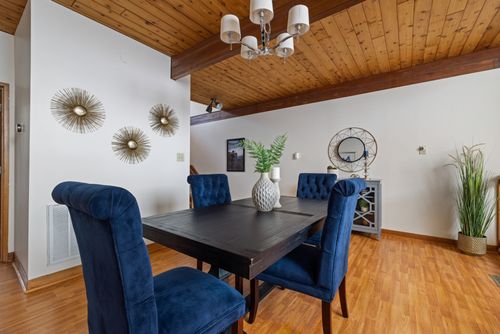 Free Elegant dining room with wooden accents and blue chairs for a cozy atmosphere. Stock Photo
