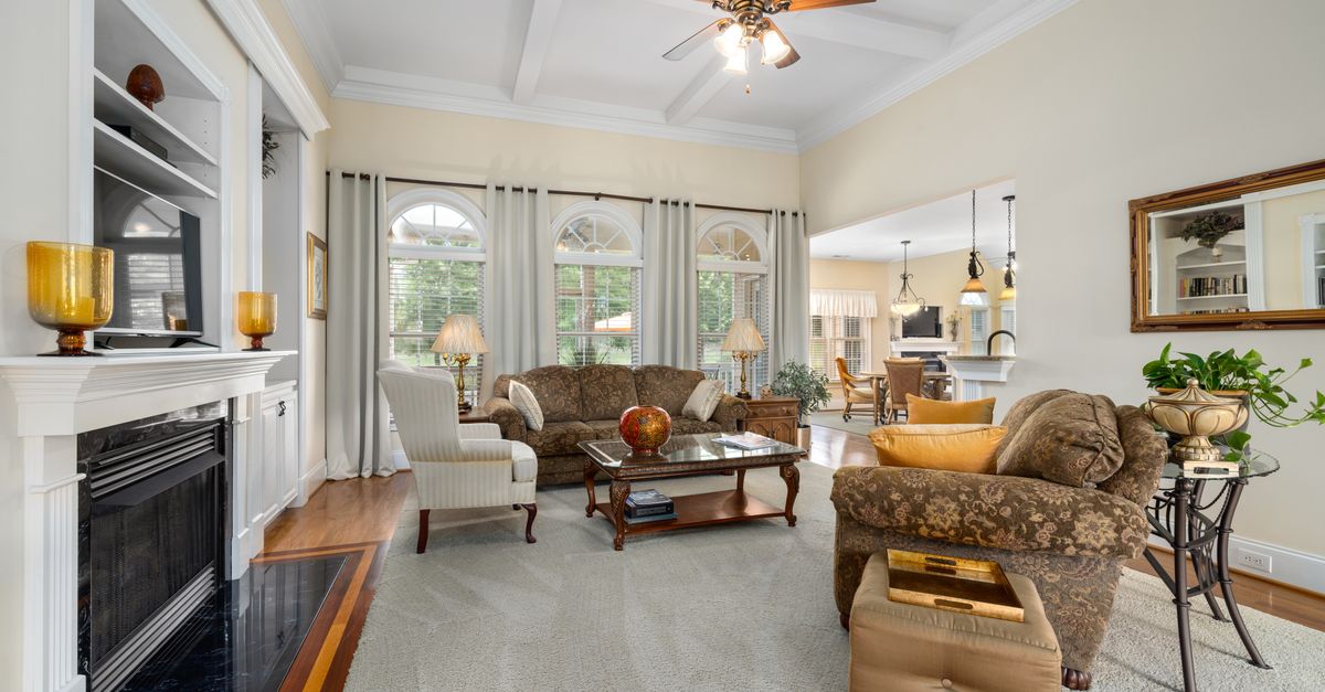 Spacious and elegantly designed living room featuring a cozy fireplace and stylish furniture.