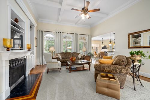 Free Spacious and elegantly designed living room featuring a cozy fireplace and stylish furniture. Stock Photo