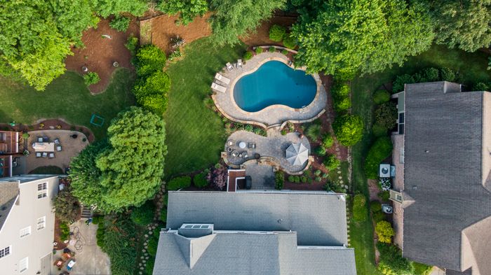 Aerial view of a suburban backyard with a pool and patio — photo by Curtis Adams on Pexels