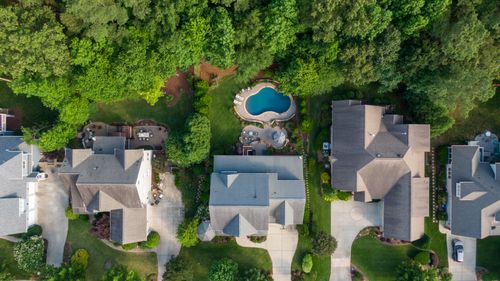 Free Aerial view of suburban neighborhood in Wake Forest, NC, showcasing lush green backyards and a swimming pool. Stock Photo