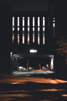 A dimly lit city passage at night creates a moody urban atmosphere.
