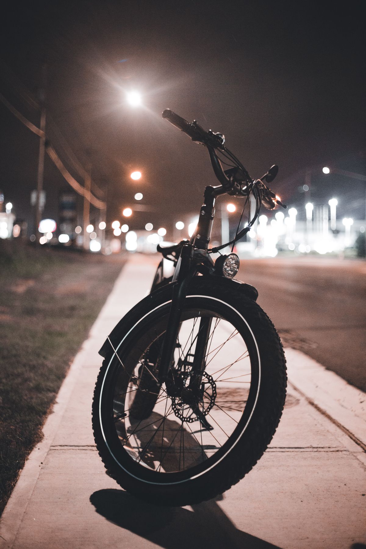 Bicycle parked along a softly illuminated city street at night