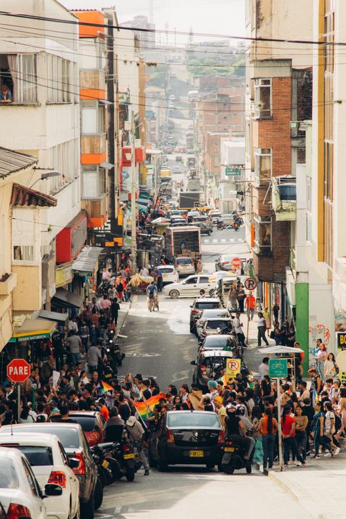 Free A bustling city street scene capturing a crowded downtown area filled with people and cars in daylight. Stock Photo