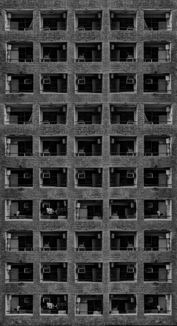 Monochrome view of a symmetrical building facade showcasing repetitive architecture.