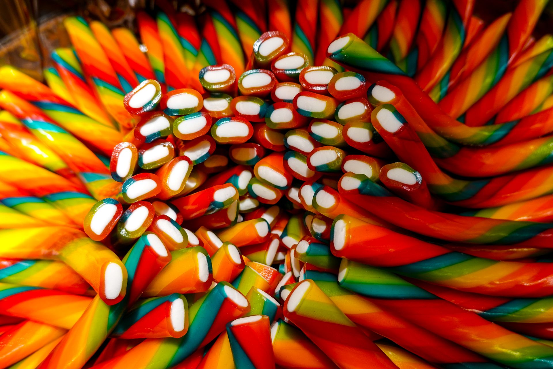 Close-up of colorful rainbow candy twists with vivid hues and intricate patterns.