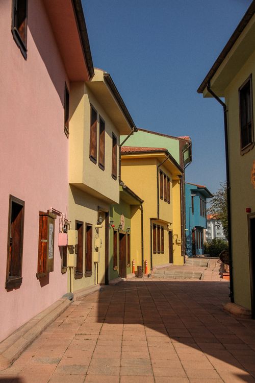 Free A vibrant alley with colorful pastel houses and clear blue sky. Stock Photo