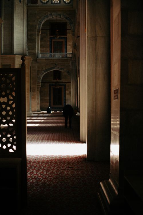 Free Sunlit corridor inside a historic mosque showcasing intricate architecture and religious ambiance. Stock Photo