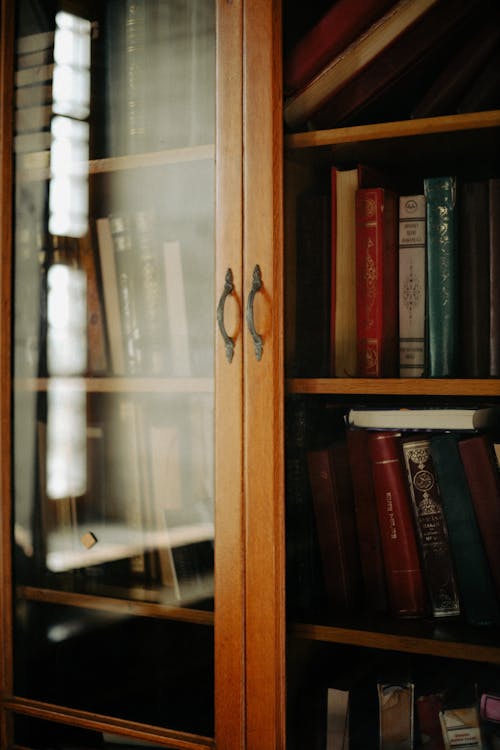 Books Inside a Wooden Cabinet with Glass Doors