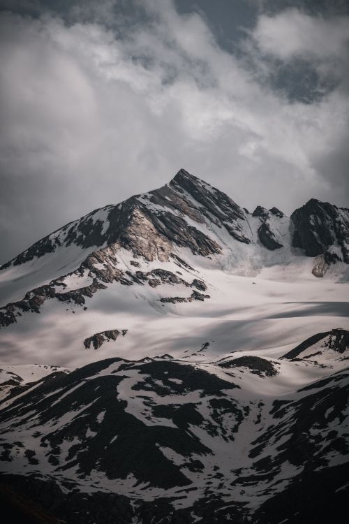 Free Snow-covered mountain peaks under a cloudy sky in Tirol, Austria, showcasing nature's beauty. Stock Photo