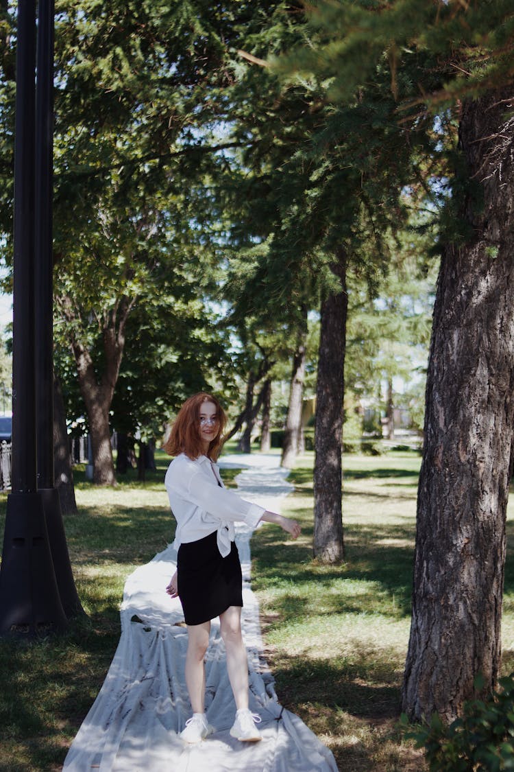 Girl Posing On A White Textile Installation In A Park 