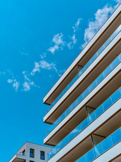 Free Contemporary building facade against a vibrant blue sky, showcasing modern urban architecture. Stock Photo